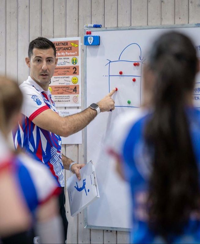 Coach explaining a play on a whiteboard to young players